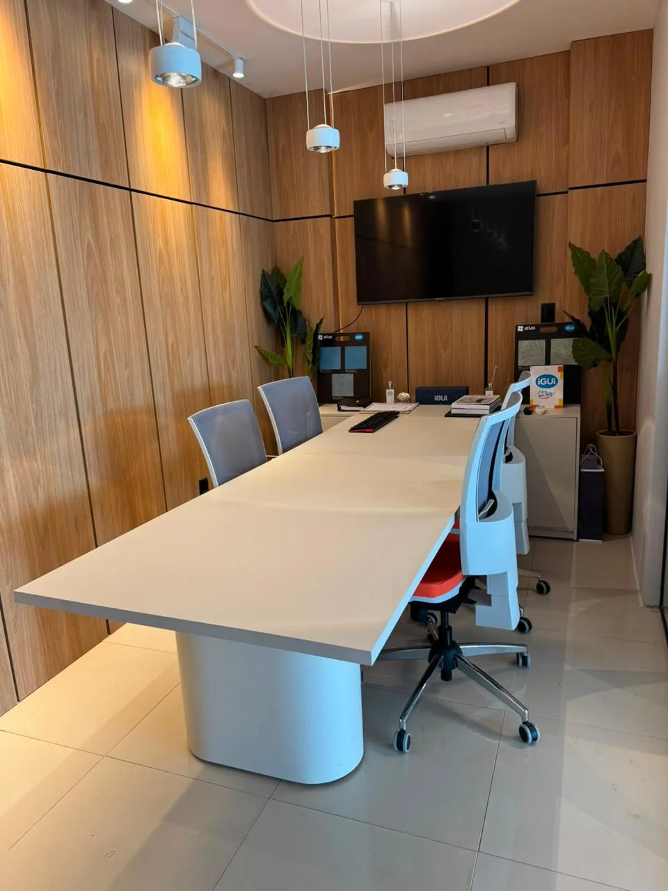 Sala de reunião iGUi com painel e mesa planejados em MDF pela Rustic